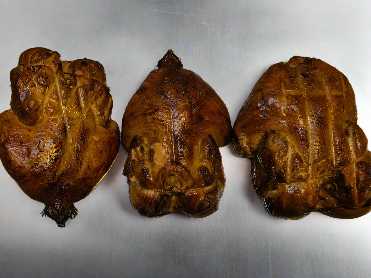 Three roasted chickens on a tray with tinfoil background